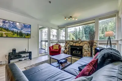 a living room with a couch and a fireplace at Greystone Lodge 328 Ski-in Out in Whistler