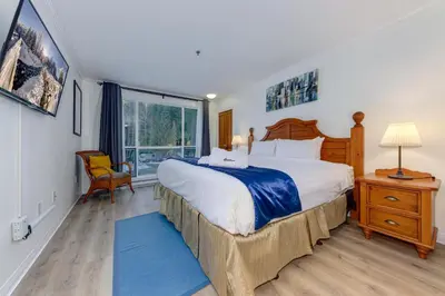 a bedroom with a large bed and a window at Greystone Lodge 328 Ski-in Out in Whistler