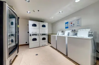 a laundry room with white machines and a counter at Greystone Lodge 207 Ski-in Out in Whistler