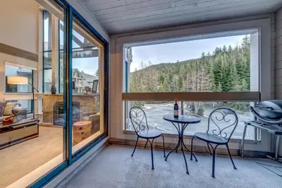 a room with a table and chairs and a large window at Greystone Lodge 412 Renovated in Whistler