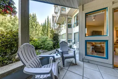 two chairs and a table on a patio at Greystone Lodge 229 Ski-in Out in Whistler