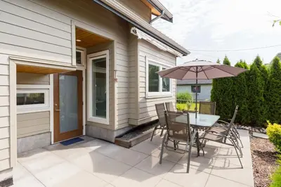 a patio with a table and chairs and an umbrella at West Coast Luxury Living in Vancouver