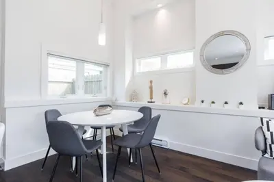 a white dining room with a white table and chairs at West Coast Luxury Living in Vancouver