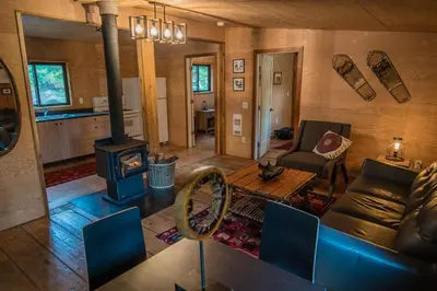 a living room with a couch and a wood stove at Chute Lake Lodge in Naramata