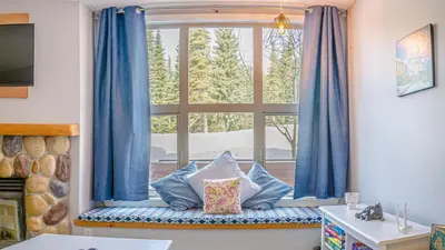 a window seat with pillows in front of a window at Crystal Forest #29 by Bear Country in Sun Peaks