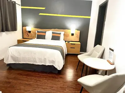 a bedroom with a bed and a table and chairs at Duncan Motel in Duncan