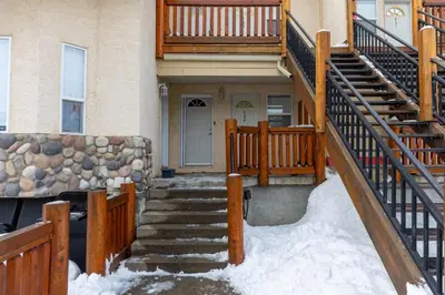 a house with snow on the stairs in front of it at Riverside Condos by Fernie Central Reservations in Fernie