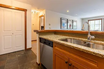 a kitchen with a sink and a dishwasher at Snow Creek Lodge by Fernie Central Reservations in Fernie