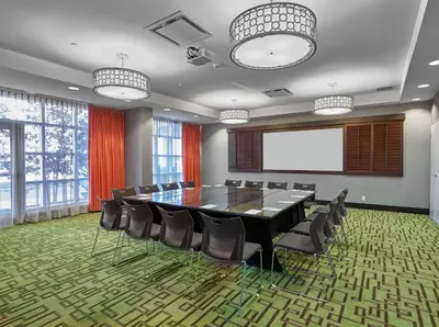 a conference room with a table and chairs and a screen at Hampton Inn by Hilton Calgary Airport North in Calgary