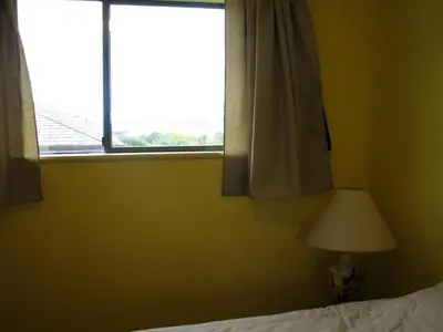 a bedroom with a window and a bed and a lamp at Fireflies Bed & Breakfast in Campbell River