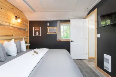 a bedroom with a large bed and a white door at The Valley View Cabins and Event Center in Creston