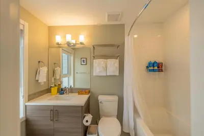 a bathroom with a toilet and a sink and a shower at 2-in-1 Skyline MTN Retreat - Hot Tub - Pool - AC in Canmore