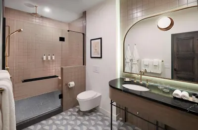 a bathroom with a sink and a toilet and a mirror at The Westley Calgary Downtown, Tapestry Collection By Hilton in Calgary