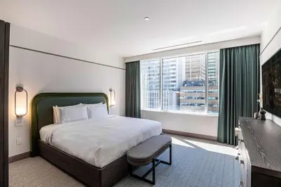 a bedroom with a bed and a large window at The Westley Calgary Downtown, Tapestry Collection By Hilton in Calgary