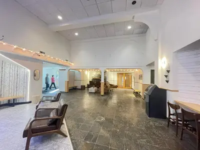 a large room with chairs and tables in a building at Windtower Lodge Queen Bed Suite-UGParking&Walking2DT in Canmore