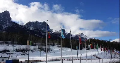 a row of flags on a ski slope with mountains at Windtower Lodge Queen Bed Suite-UGParking&Walking2DT in Canmore