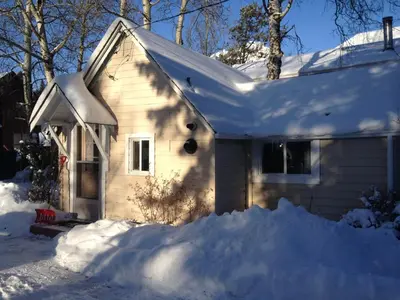 a house covered in snow with a pile of snow at Holiday Lodge Cabins in Banff