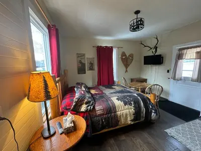 a bedroom with a bed and a table with a lamp at Holiday Lodge Cabins in Banff