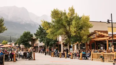 a crowd of people sitting at tables on a street at Apartment 406, Indigenous Artefacts in Canmore