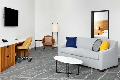 a living room with a couch and a desk at Delta Hotels by Marriott Grande Prairie Airport in Grande Prairie