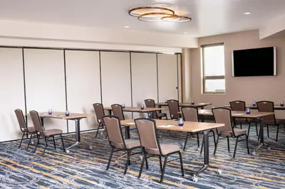 a conference room with tables and chairs and a flat screen tv at Delta Hotels by Marriott Grande Prairie Airport in Grande Prairie
