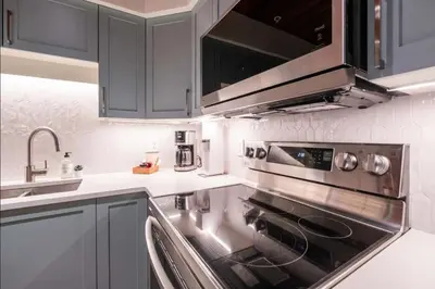 a kitchen with a stainless steel stove and a sink at Snowberry by Outpost Whistler in Whistler