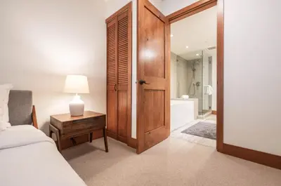 a bedroom with a bed and a table with a lamp at Snowberry by Outpost Whistler in Whistler