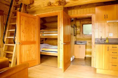 a room with bunk beds in a log cabin at Porteau Cove Olympic Legacy Cabins in Furry Creek