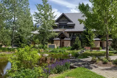 a house with a pond in front of a garden at Renovated & Spacious 1bed/2bath Whistler Village in Whistler