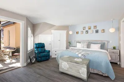 a bedroom with a bed and a blue chair at Renovated & Spacious 1bed/2bath Whistler Village in Whistler