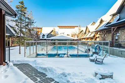 a swimming pool covered in snow next to a house at Mystic Getaway in Canmore