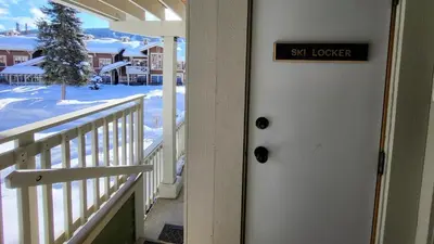a sign on the door of a house with a snow covered yard at Settlers Crossing #41 by Bear Country in Sun Peaks