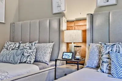 a room with two beds with pillows and a table at The Versailles by Samsara Resort Top Luxury Top View 1300SQF 2BEDROOM 2BATHROM in Canmore