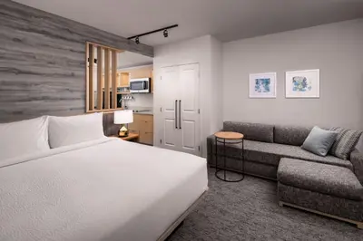 a bedroom with a white bed and a couch at TownePlace Suites by Marriott West Kelowna in West Kelowna