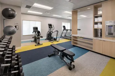 a gym with exercise equipment and chairs in a room at TownePlace Suites by Marriott West Kelowna in West Kelowna