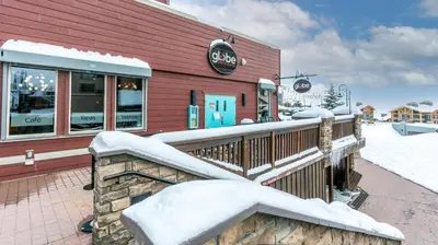 a restaurant covered in snow in front of a building at Forest Lane Hideaway - Luxurious Family Friendly Home w Private Hot Tub in Big White