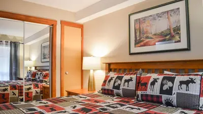 a bedroom with a bed and a mirror at Fireside Lodge #215 by Bear Country in Sun Peaks
