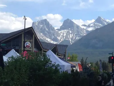 a building with a mountain range in the background at Apartment 407, Contemporary Decor in Canmore