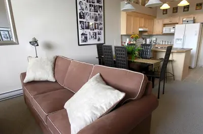 a living room with a couch and a kitchen at Apartment 407, Contemporary Decor in Canmore