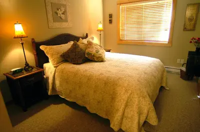 a bedroom with a bed with pillows and a window at Apartment 411, Antique Heritage in Canmore
