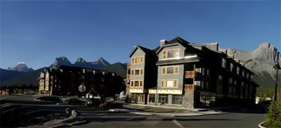 a large building on a street with mountains in the background at Apartment 411, Antique Heritage in Canmore