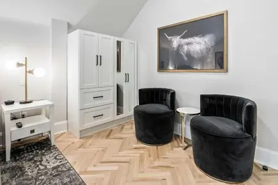 a living room with two chairs and a mirror at The Inn on Officers' Garden in Calgary