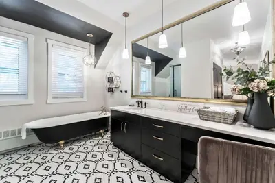 a bathroom with a tub and a large mirror at The Inn on Officers' Garden in Calgary