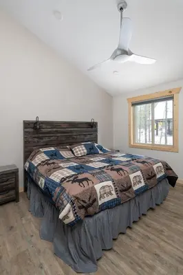 a bedroom with a bed with a quilt on it at Lazy Moose in Valemount