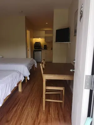 a room with two beds and a table and a kitchen at Coquihalla Motel in Hope