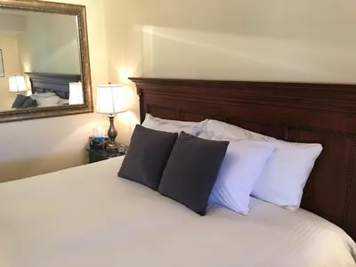 a bedroom with a bed with two pillows and a mirror at All Seasons Bed & Breakfast in Kelowna