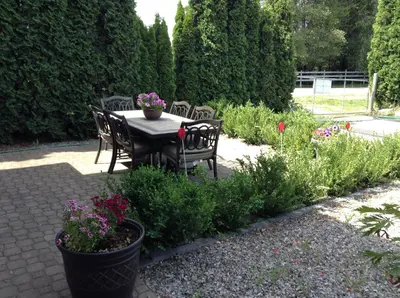 a table and chairs in a garden with flowers at All Seasons Bed & Breakfast in Kelowna
