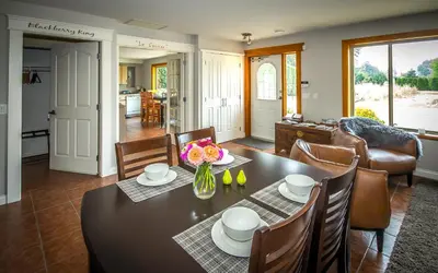 a dining room and living room with a table and chairs at All Seasons Bed & Breakfast in Kelowna