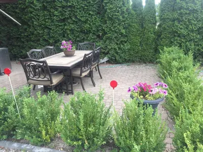 a patio with a table and chairs and flowers at All Seasons Bed & Breakfast in Kelowna