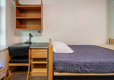 a bedroom with a bed and a desk and a bed at Pacific Spirit Hostel in Vancouver
